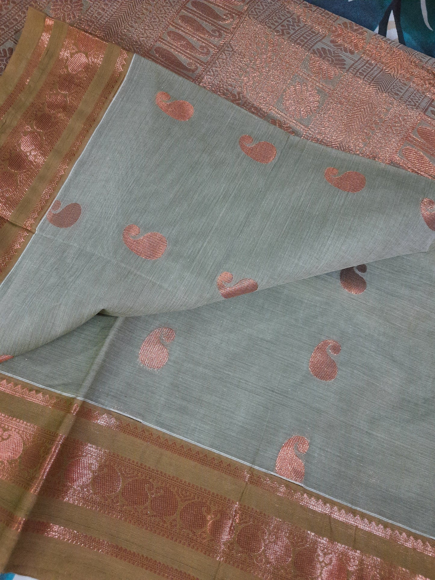 Close-up of Handloom Organic Cotton with Copper Zari, showcasing intricate weaving and shiny finish