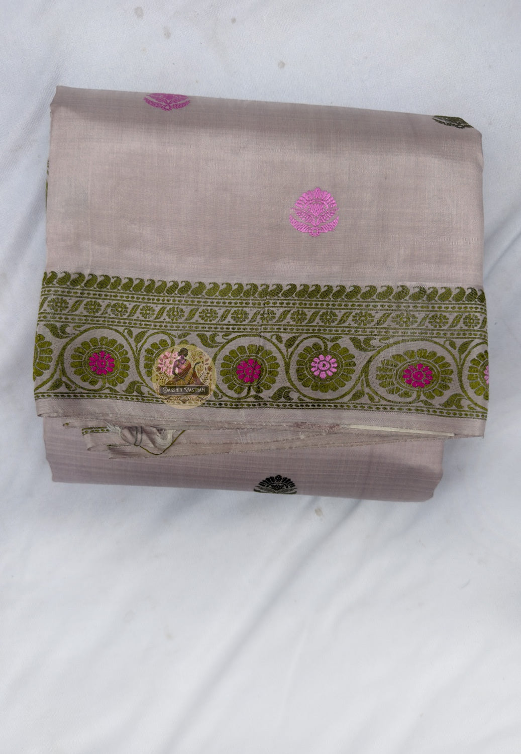 Full saree view highlighting taupe silk folds, patterned borders and the pink-accented paisley pallu