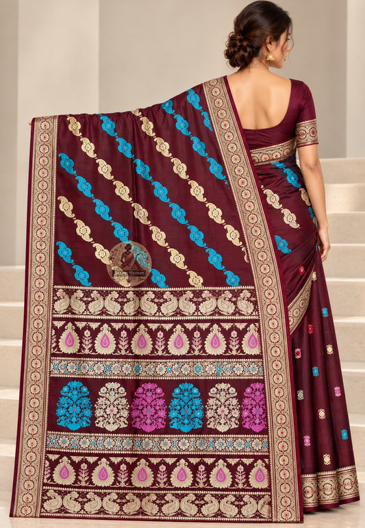 Side view of wine Baluchari silk saree showing lustrous folds and a pale circular-medallion border