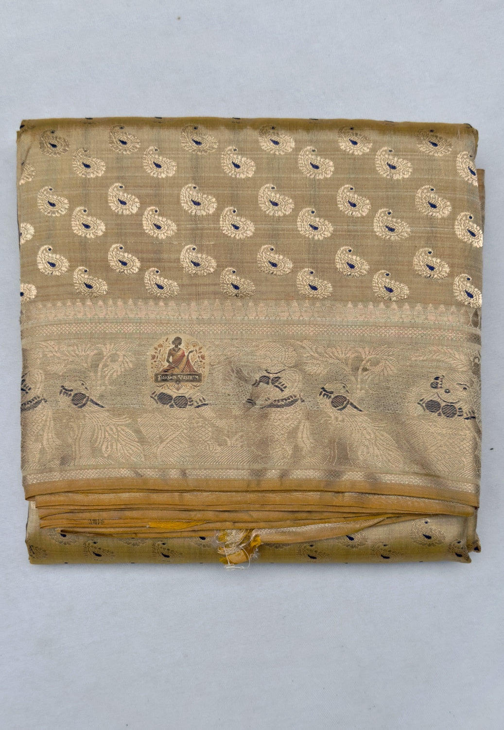 Close-up of premium Swarnachari silk saree pallu showing finely resolved hand-woven golden zari composition with Mughal-era courtly procession detail