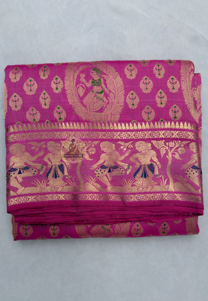 Full flat-lay of premium Swarnachari pure silk saree with golden zari story-in-waiting border, suspended narrative pallu, precise buti field, and matching unstitched blouse piece, West Bengal handloom