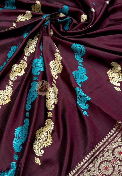 Close up of diagonal turquoise and pale paisley motifs across the wine silk body