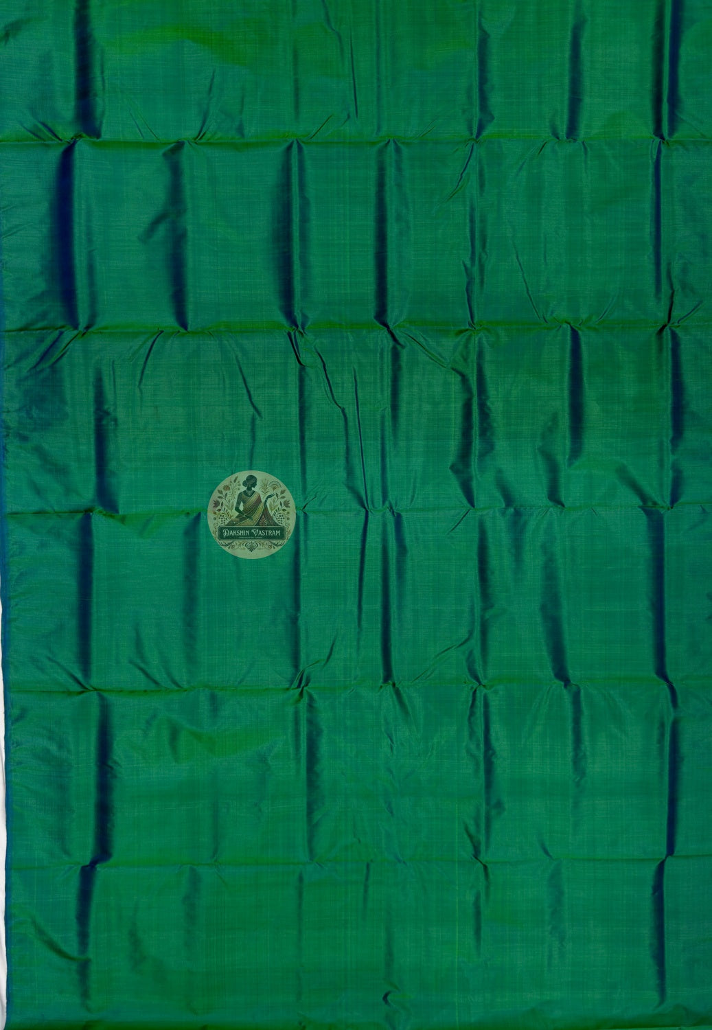 Close up of emerald green Bishnupur silk fabric with light reflecting across the folds