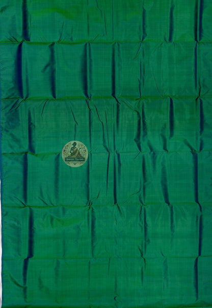 Close up of emerald green Bishnupur silk fabric with light reflecting across the folds