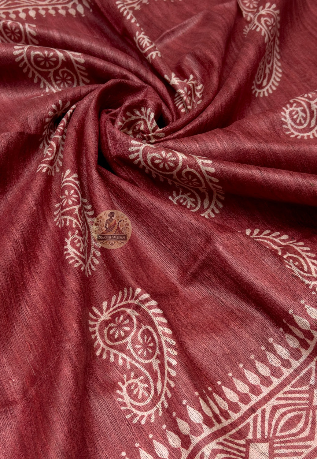 Close up of pale paisley motifs on the deep red Ghicha Tussar silk saree body