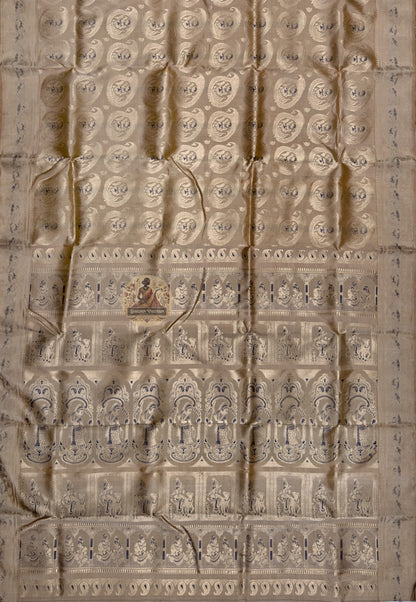 Close-up of premium Swarnachari silk saree pallu showing devotion-grade hand-woven golden zari with unified mythological scene and Bengal temple tradition motifs relating across the panel