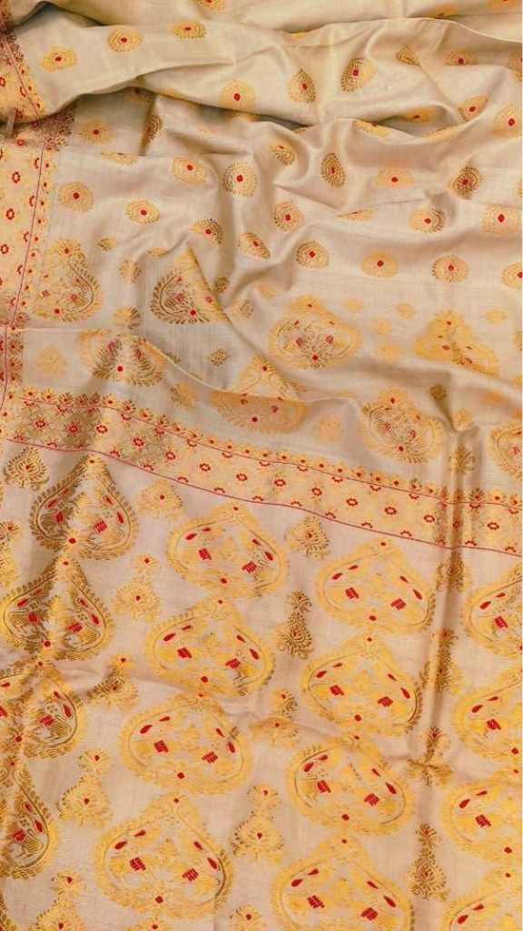 Front view of handloom Muga silk saree from Assam's Brahmaputra valley with naturally golden sheen from Antheraea assamensis silk, clean handloom weave and considered border