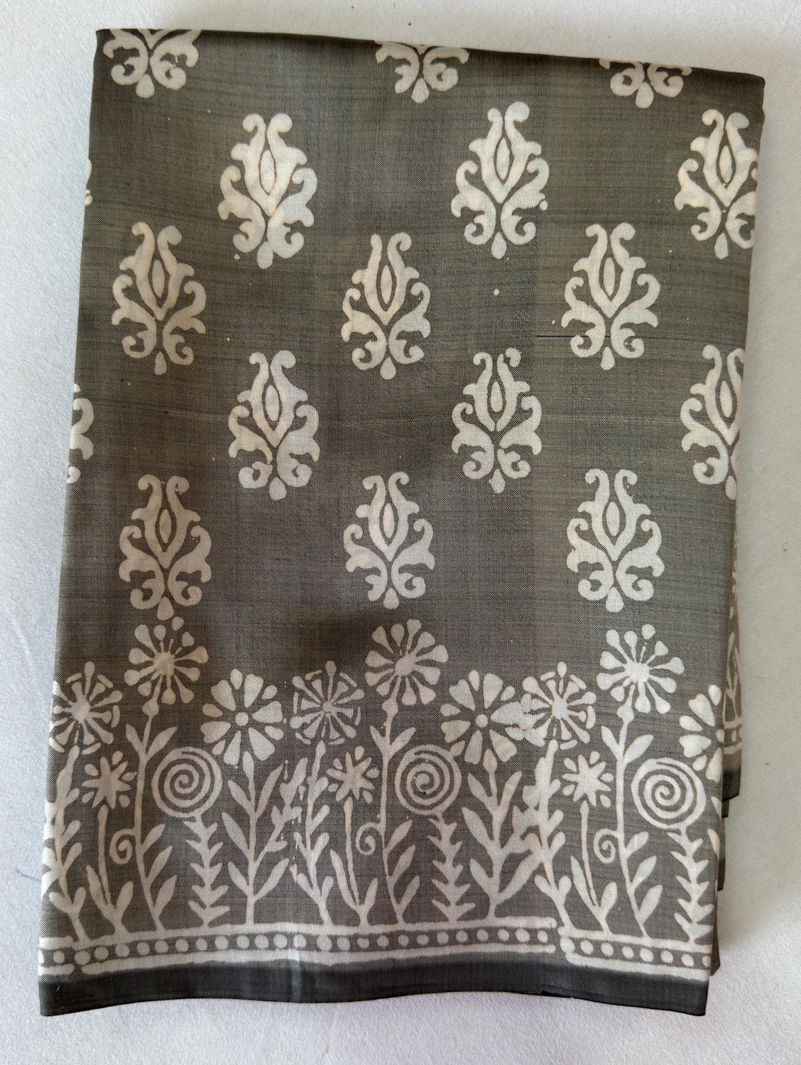 Close-up of Bishnupur Katan silk saree pallu showing hand block print composition with terracotta-inspired floral and figurative motifs pressed into pure silk using carved wooden blocks, Bishnupur West Bengal