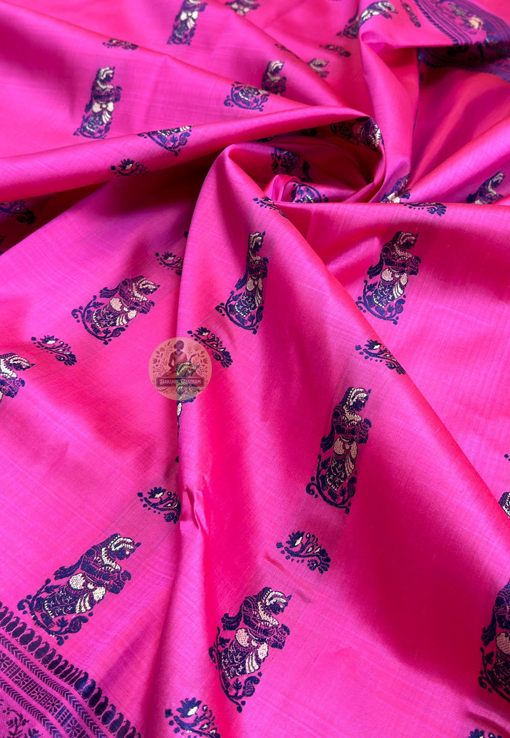 Full flat-lay view of Rani Pink Baluchari Silk Saree showing complete handwoven magenta silk body with navy buti, narrative border frieze of seated figures beneath flowering trees, and richly illustrated pallu medallions