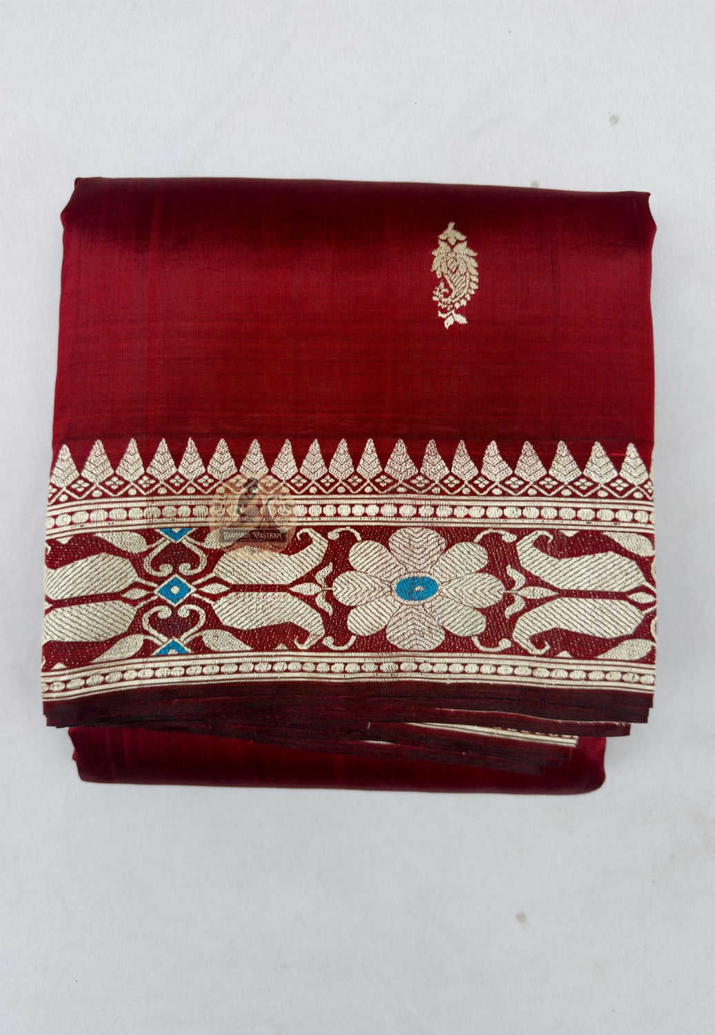 Close up of small blue and pale-toned motifs on the maroon Baluchari silk saree body