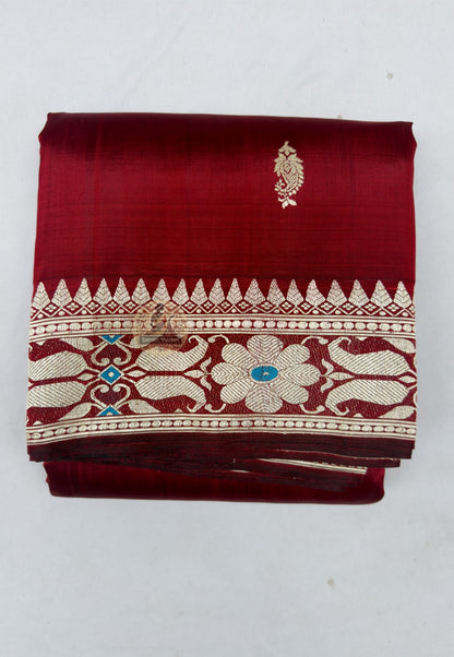 Close up of small blue and pale-toned motifs on the maroon Baluchari silk saree body
