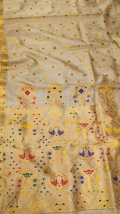 Macro detail of Muga silk weave showing naturally golden hand-reeled thread and traditional Assamese loom pattern