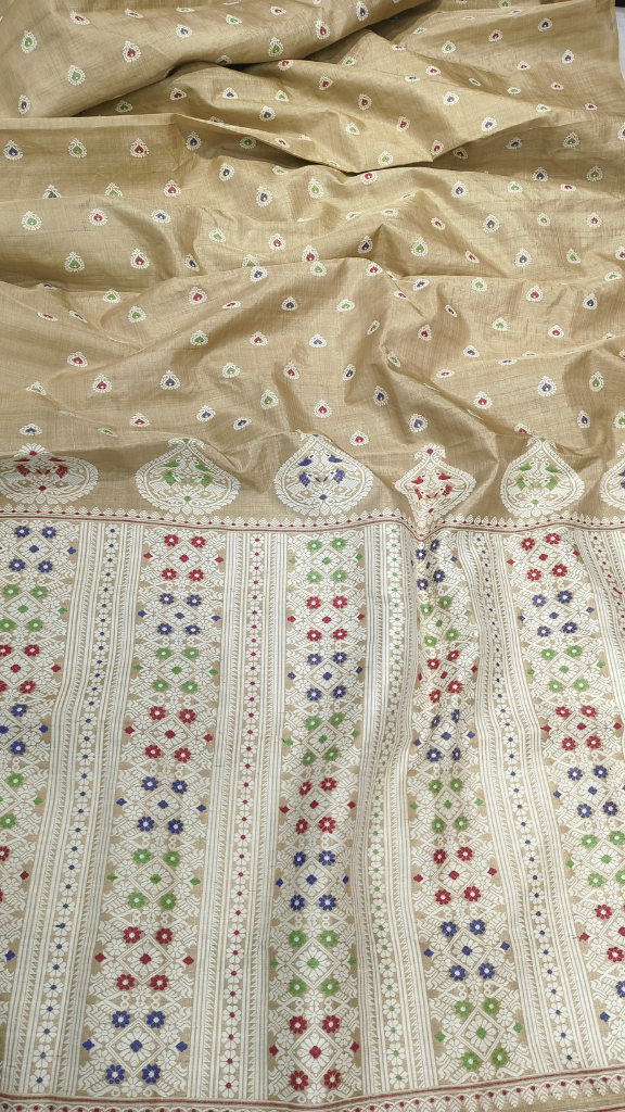 Close-up of aged Muga silk weave showing naturally deepening golden oxidised thread and fine handloom density — Assam heirloom craftsmanship