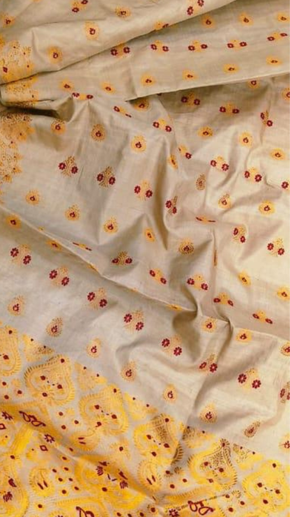 Front view of woman in handloom Muga silk saree, traditional drape showing natural golden Assam silk sheen deepening in light, blouse piece in matching Muga silk