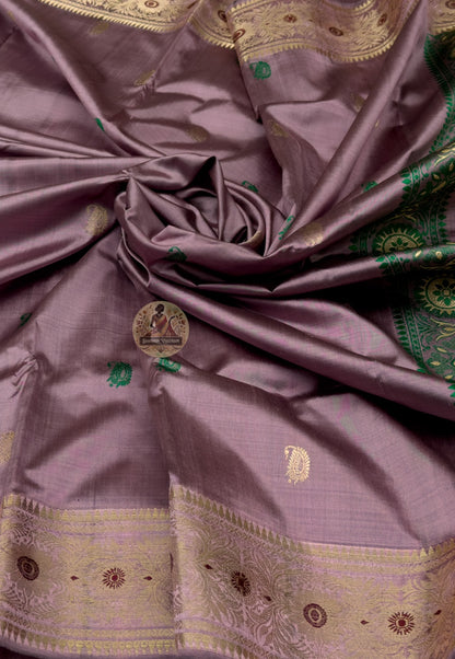 Close-up of Swarnachari handloom silk saree body showing warm pure silk ground with fine golden zari butis (small woven motifs) as small declarations of Bengal's soul across the field