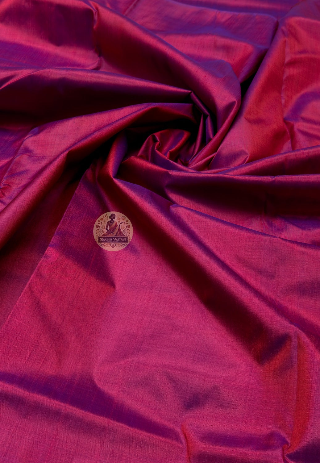 Close up of deep pink Bishnupur silk fabric with light reflecting across the folds