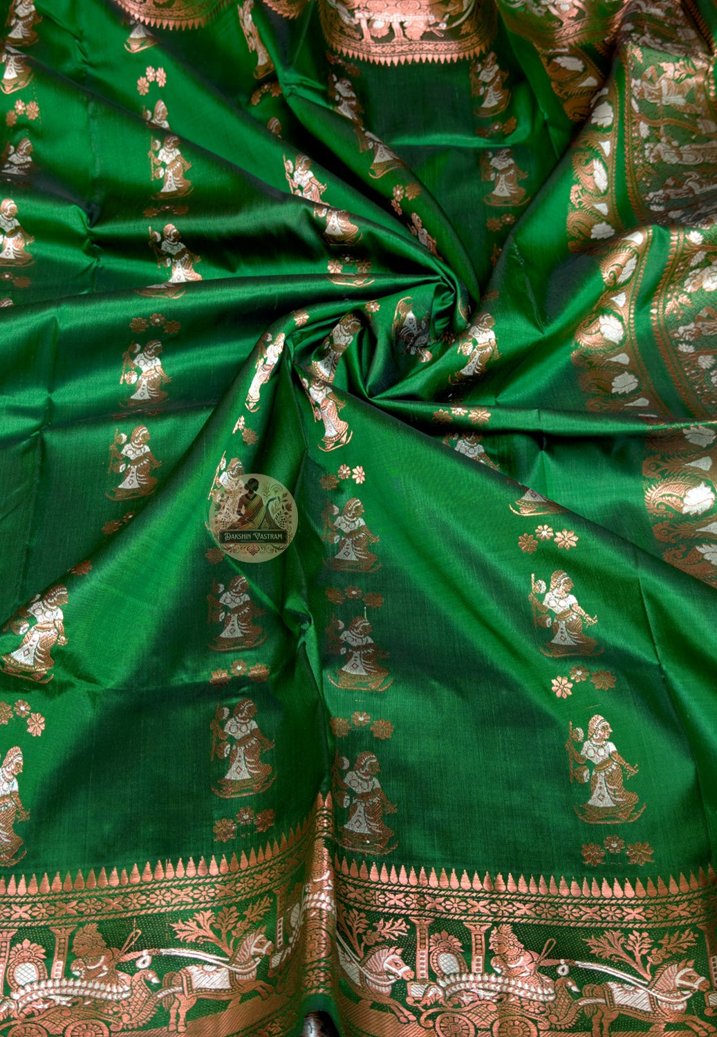 Close-up of Swarnachari silk saree pallu showing finely resolved hand-woven golden zari detail panel with Bengal royal court and temple sculpture motifs rewarding close inspection