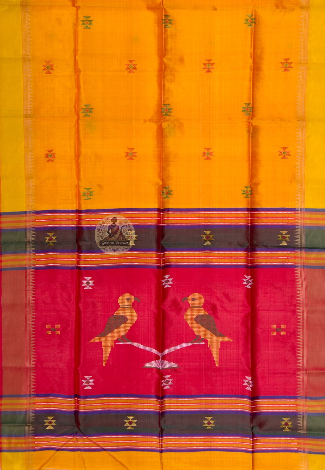 Close up of the red pallu featuring two stylised birds perched on a pale branch-like form