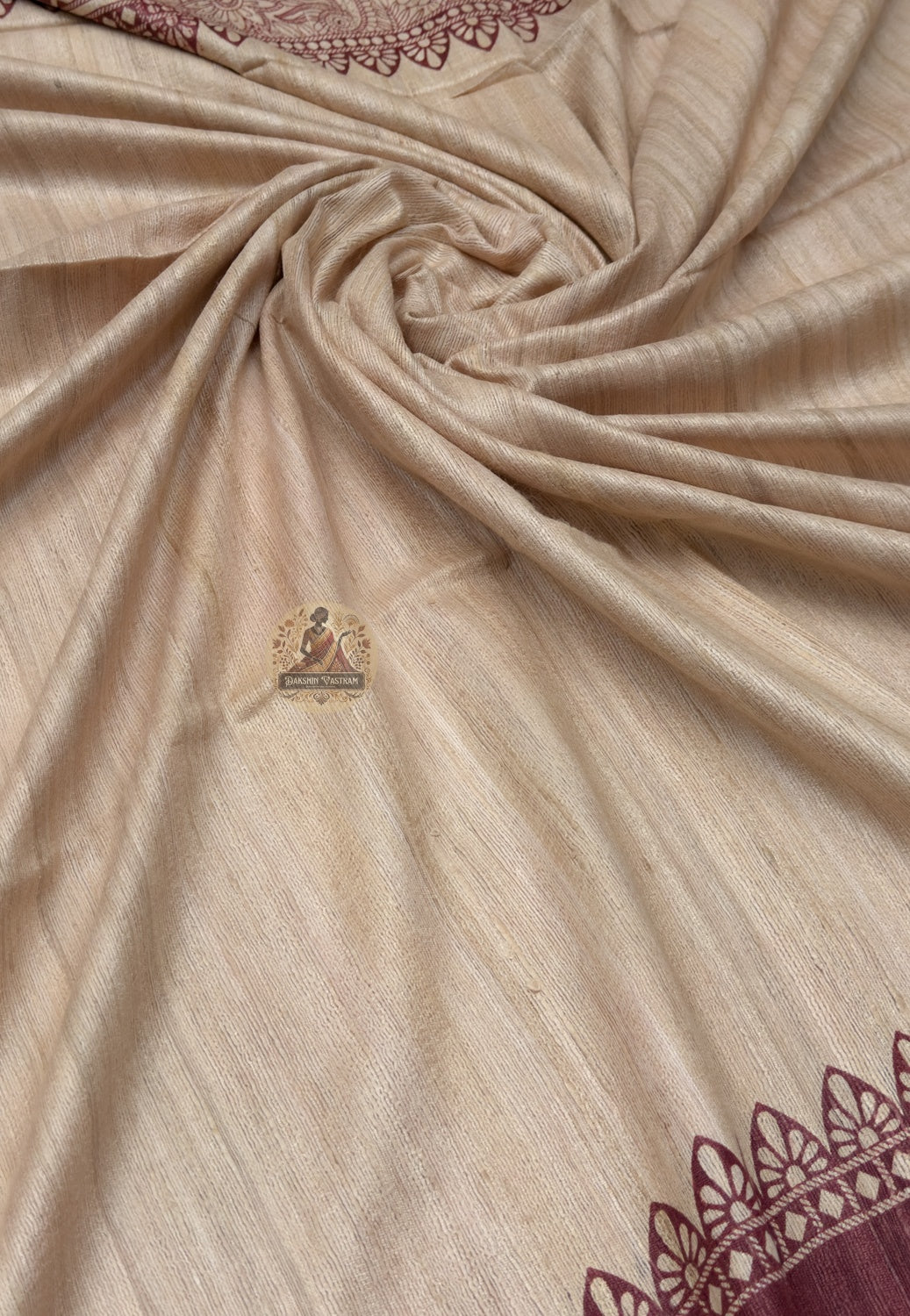 Close up of the Ghicha Tussar saree pallu showing a central figurative panel, curved motifs and dotted bands