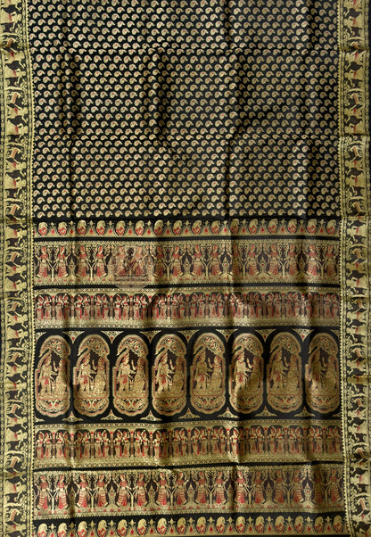 Full saree view of black Baluchari silk saree with patterned body, contrasting borders and figurative pallu