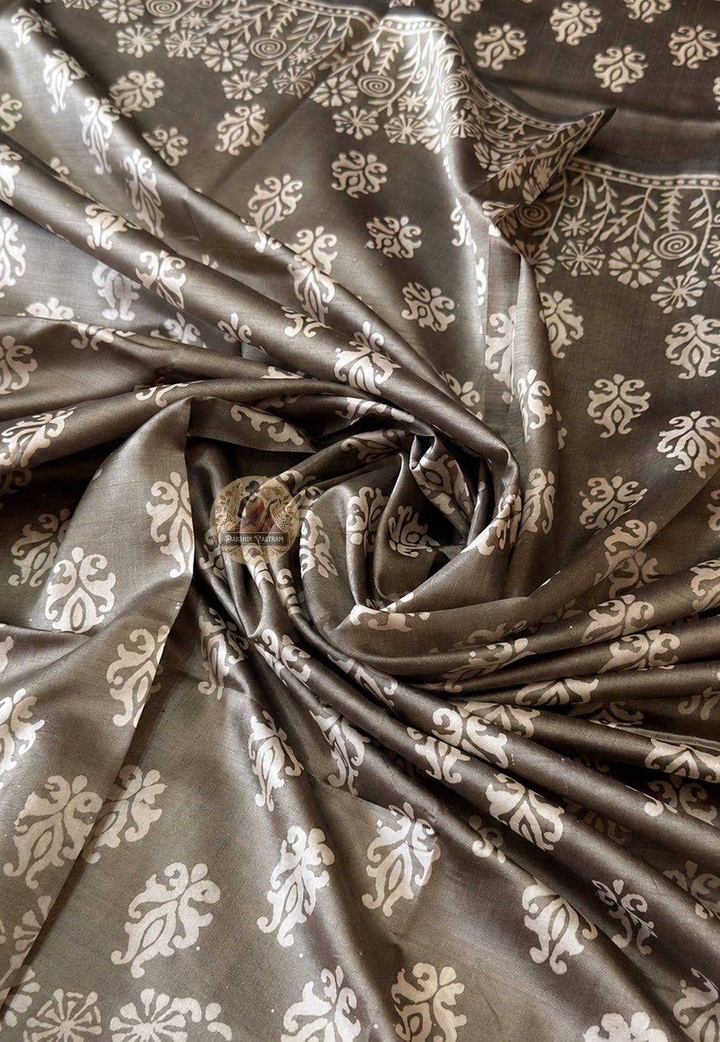 Full flat-lay of Bishnupur Katan silk saree with hand block print pallu, terracotta-heritage border panels, considered body field, and matching unstitched blouse piece, West Bengal heritage craft