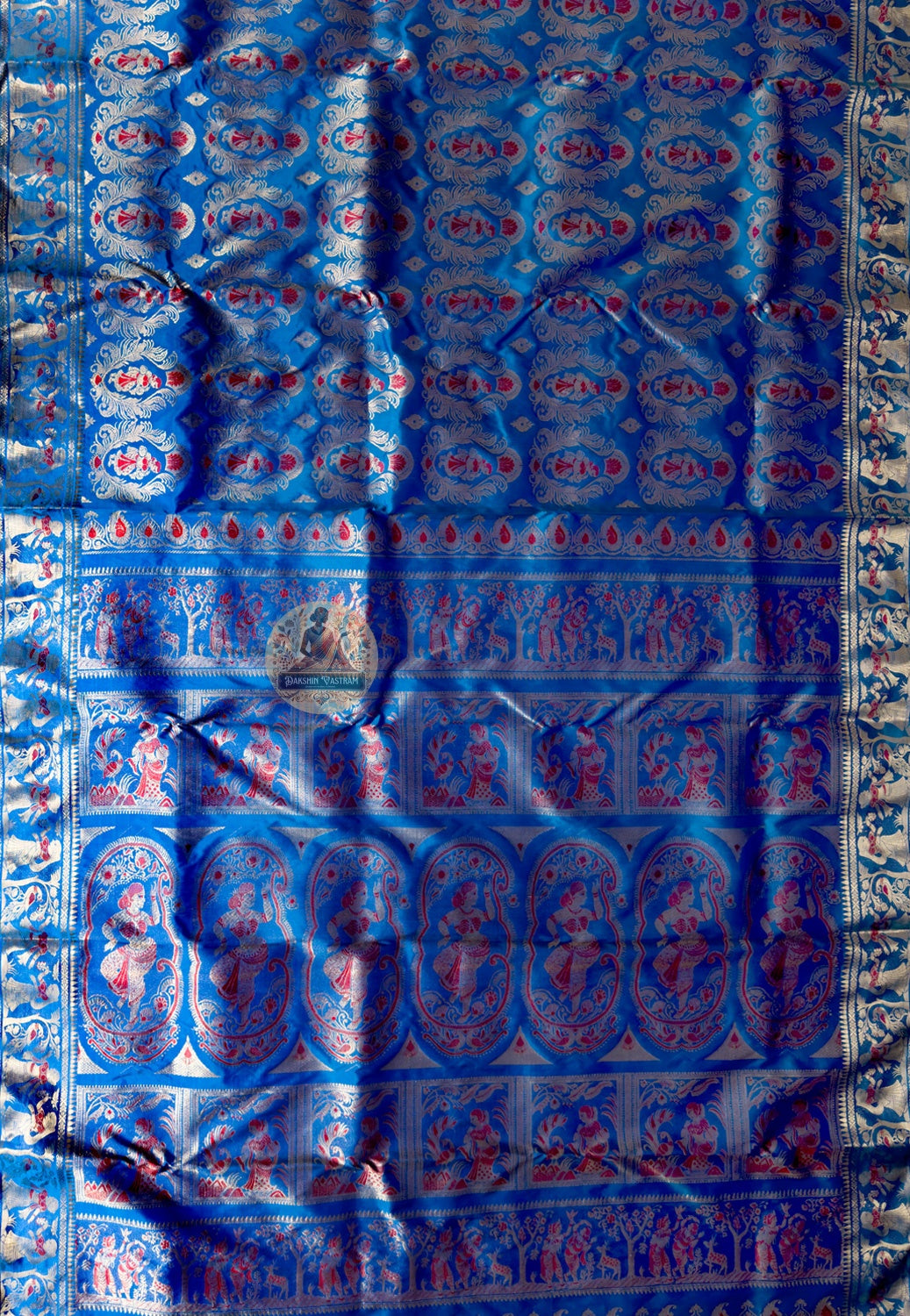 Side view of blue Swarnachari pure silk saree displaying natural fluid drape and golden zari luminosity against bright blue silk ground for morning ceremony through evening reception