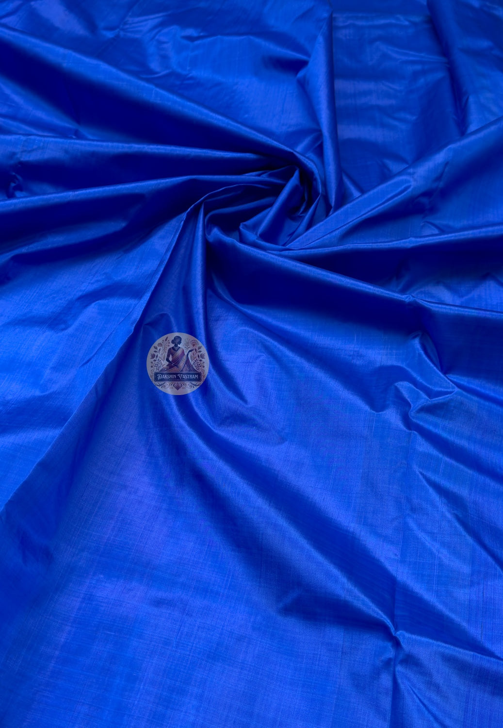 Close up of royal blue Bishnupur silk fabric showing its sheen and subtle surface texture