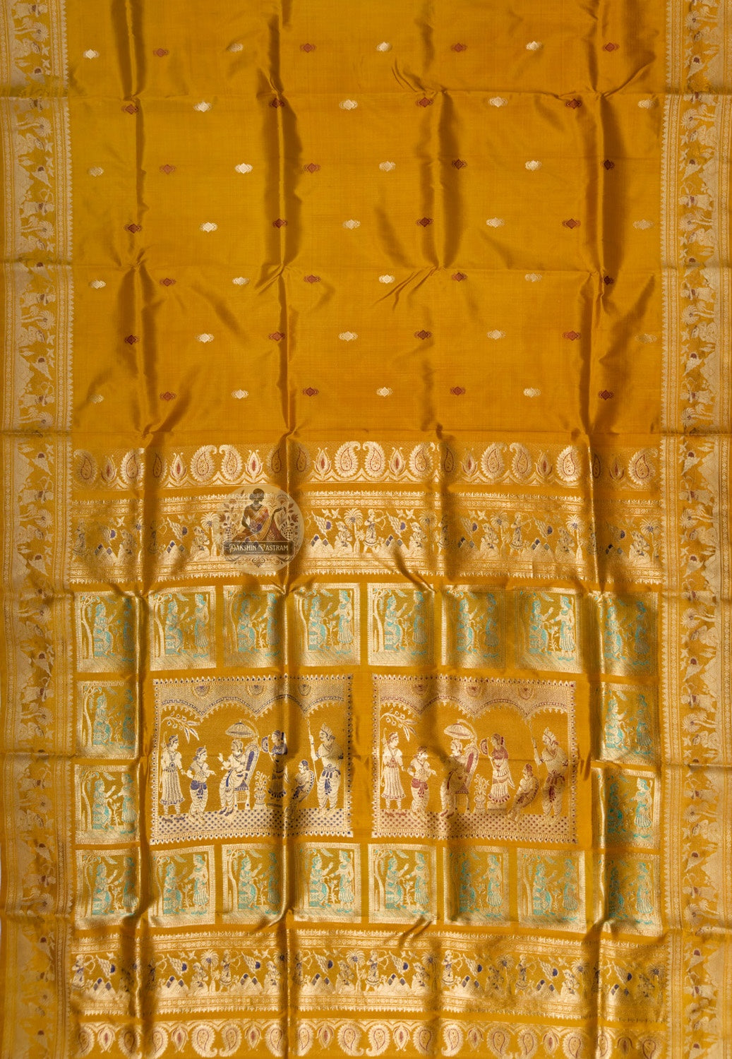 Close up of small pale and dark-toned motifs on the mustard-gold silk saree body