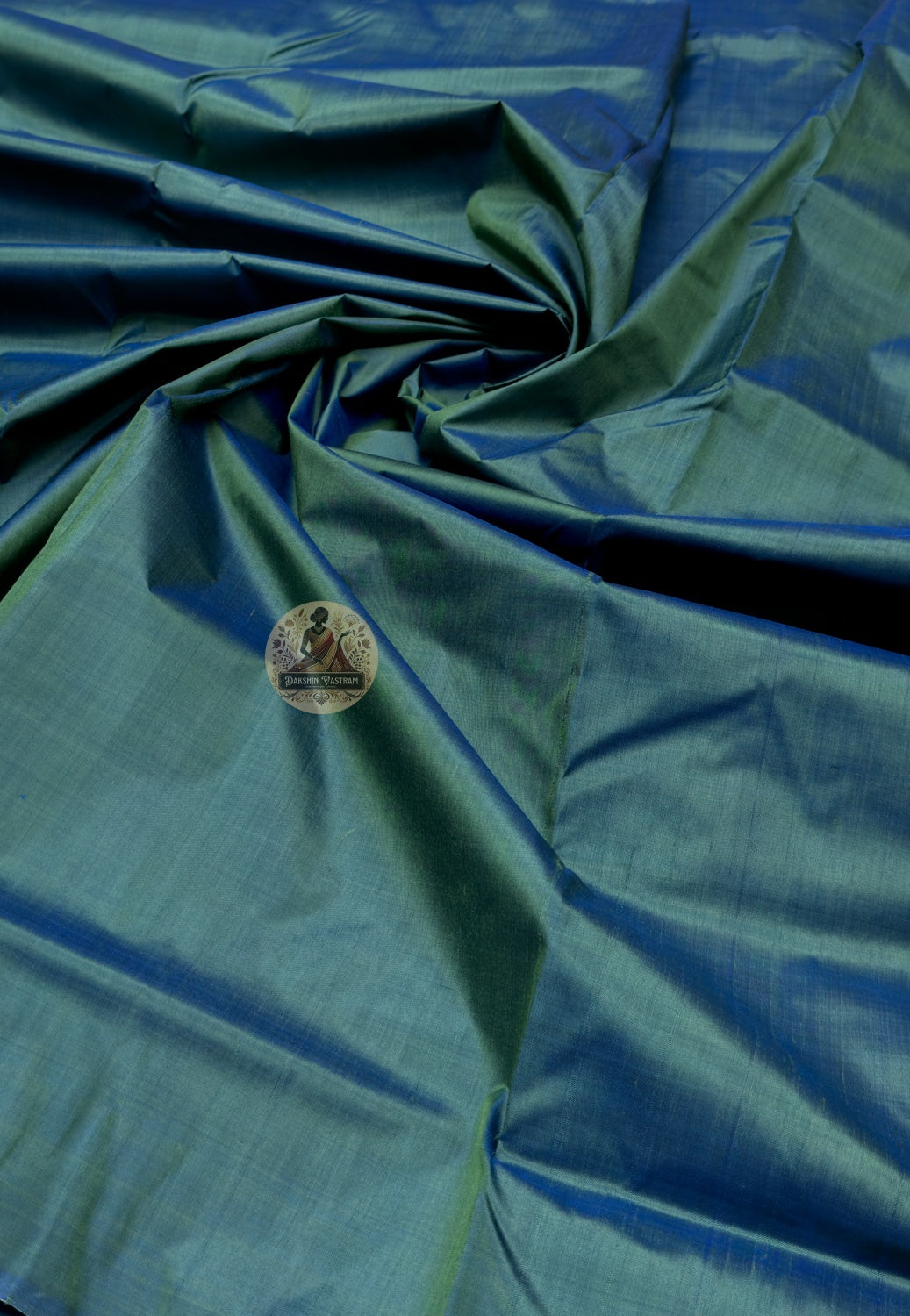 Close up of deep green Bishnupur silk fabric with light reflecting across the folds