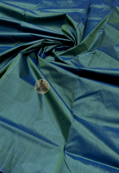 Close up of deep green Bishnupur silk fabric with light reflecting across the folds
