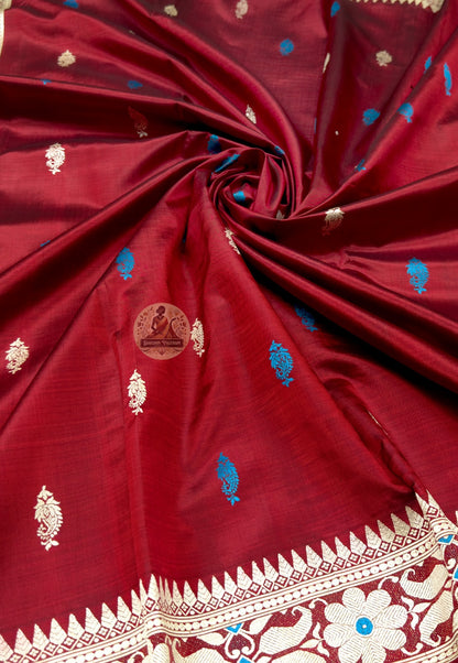 Full saree view of maroon Baluchari silk saree with scattered motifs and a decorative blue-accented pallu