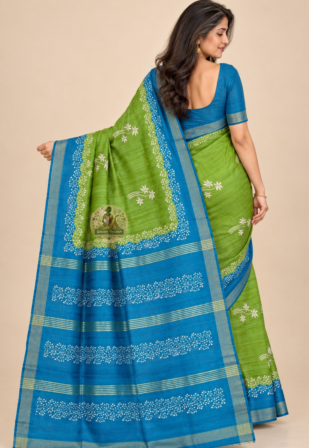 Rear view of green Ghicha Tussar silk saree with the blue floral pallu draped over the shoulder