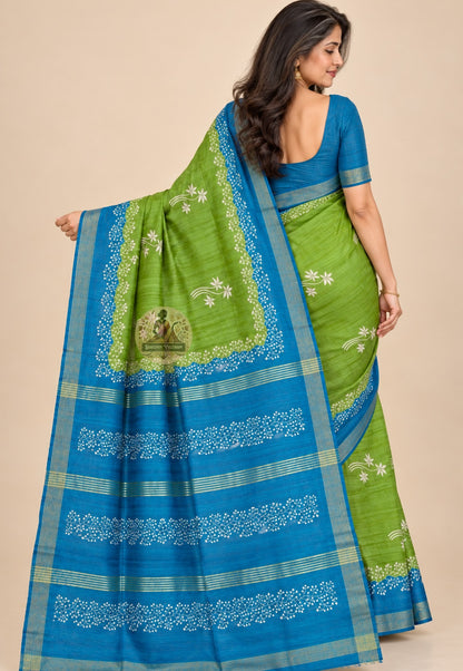 Rear view of green Ghicha Tussar silk saree with the blue floral pallu draped over the shoulder