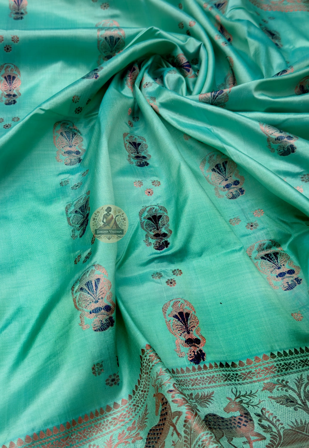 Close up of green Swarnachari silk saree pallu with figurative panels and arch-shaped patterns