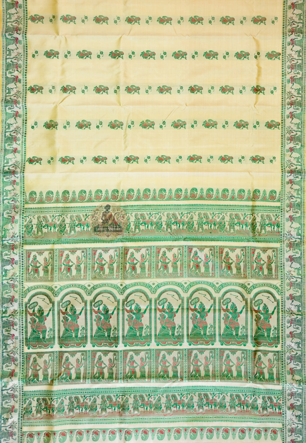 Close-up of Beige Baluchari silk pallu with hand-woven mythological figures — celestial dancers, royal processions and temple motifs — emerging from the warm beige silk ground