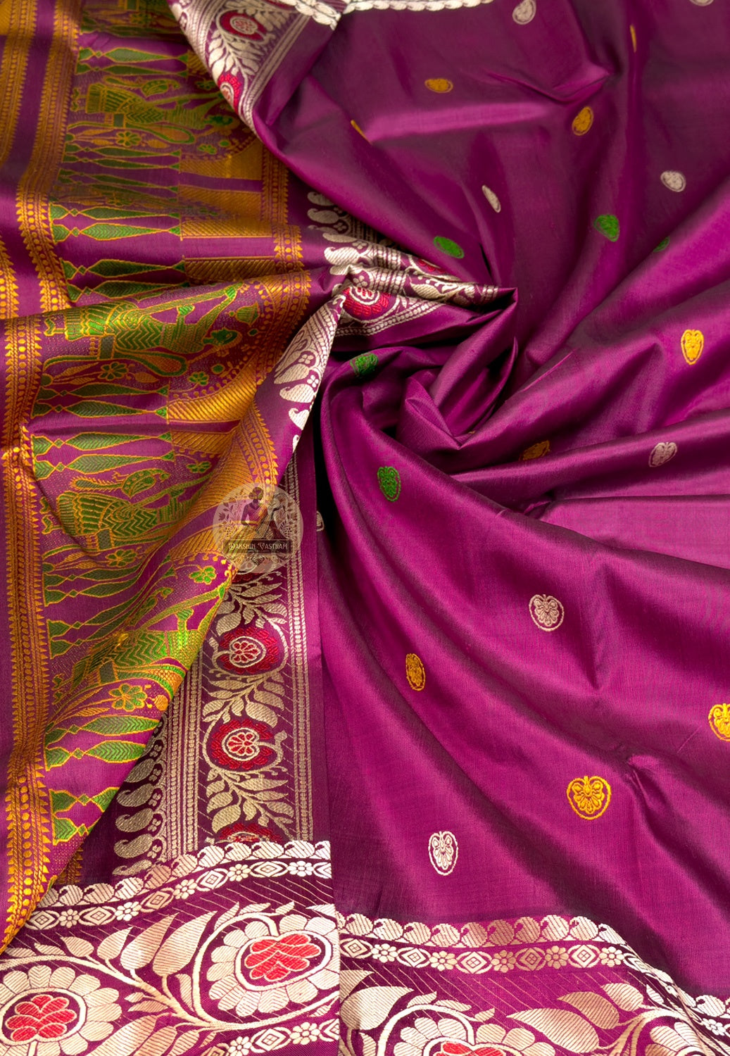 Close-up of Baluchari silk pallu with hand-woven mythological figures placed with the reverence of a master weaver who knows this saree will be worn at a wedding, a puja or a celebration that will be remembered for years