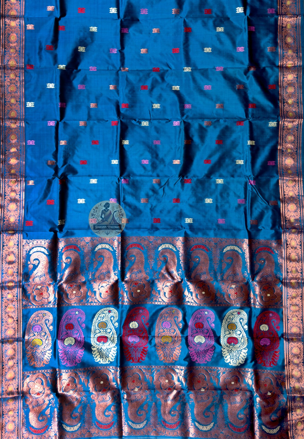 Side view of premium Swarnachari handloom silk saree showing wide patiently executed golden zari border and warm pure silk drape held with quiet authority, West Bengal weave