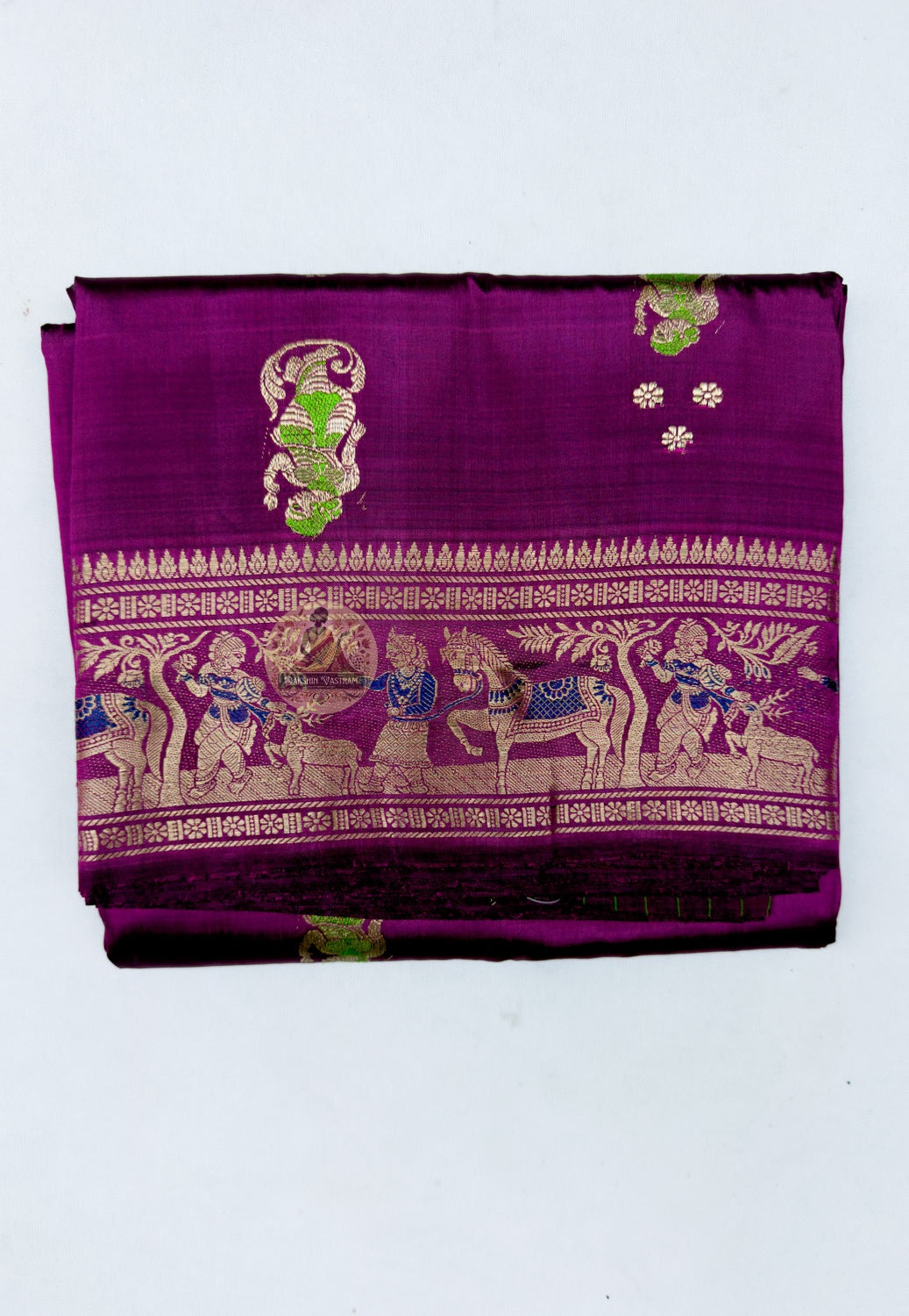 Close up of gold-toned woven motifs and small accents on the plum magenta saree body