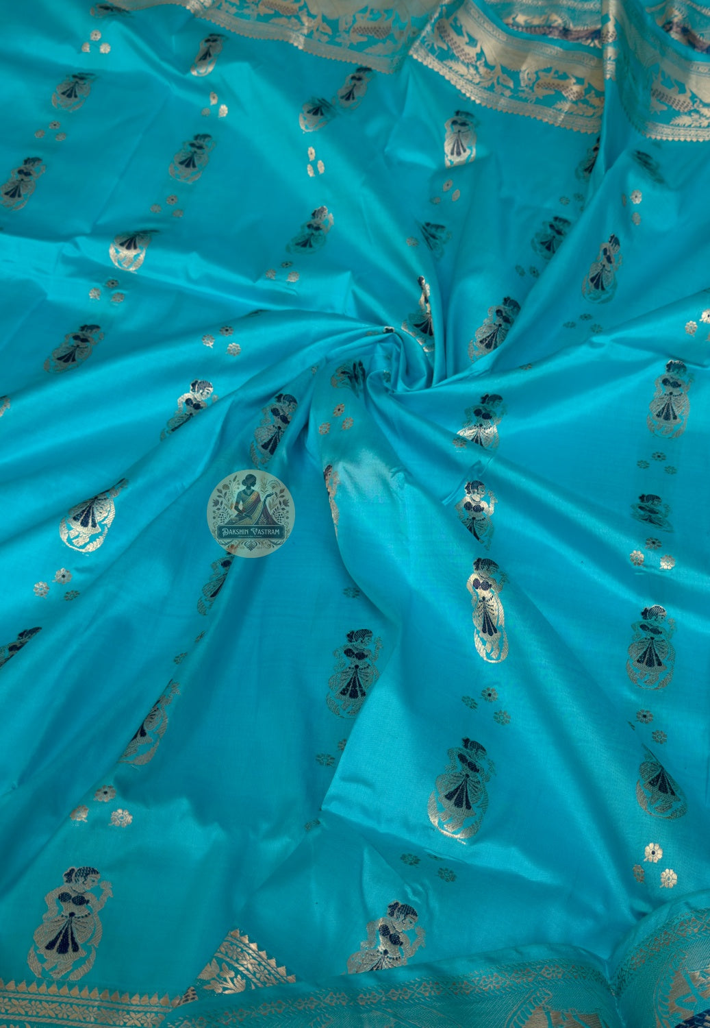 Close-up of Swarnachari handloom silk saree body showing warm pure silk ground with hand-thrown shuttle texture and fine golden zari butis (small woven motifs) in rhythmic spacing