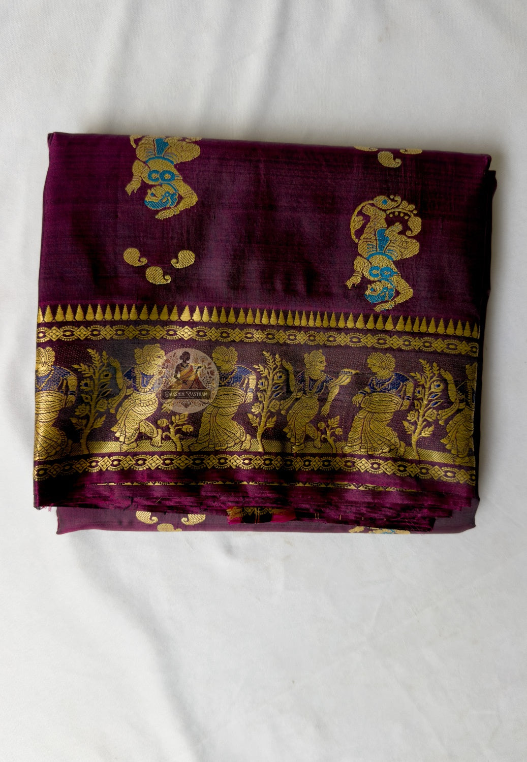 Close-up of coffee Baluchari silk saree weave showing individually woven Ramayana mythology figures and Bishnupur narrative compositions in coloured silk thread against warm coffee ground