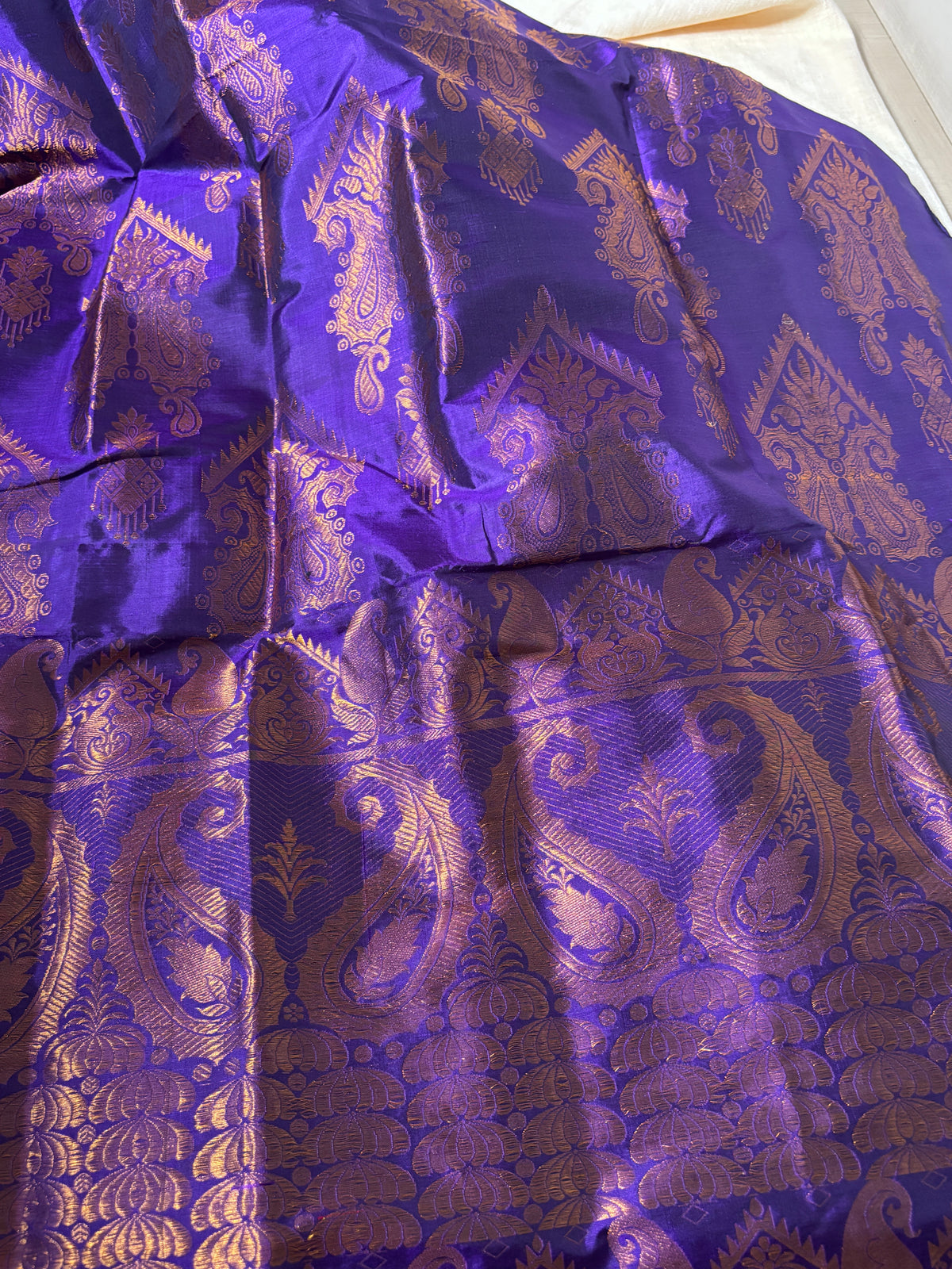 Close-up of handwoven peacock mayur and lotus pond border detail on Paat Mekhela Chador authentic Sualkuchi Assam mulberry silk craft