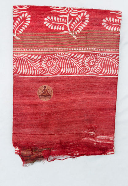 Close up of the red saree pallu featuring rows of flowering plants, diamond patterns and scrolling ornamental bands