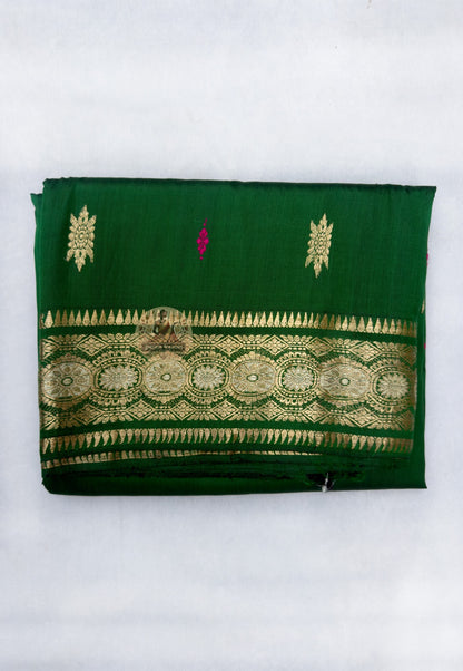 Full flat-lay of Swarnachari pure silk saree with golden zari witness border, tradition-carried pallu, endurance buti field, and matching unstitched blouse piece, West Bengal handloom