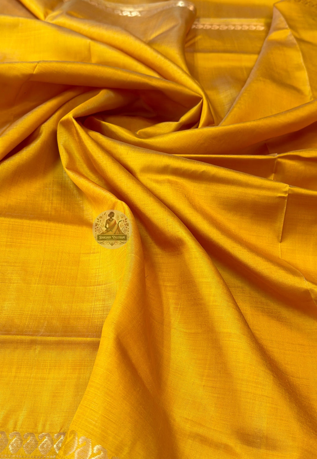 Close-up of Bishnupur Katan silk pallu with hand-woven heritage motifs placed with the care of a weaver who knows this saree will travel far from where it was made and needs to carry something of Bishnupur with it