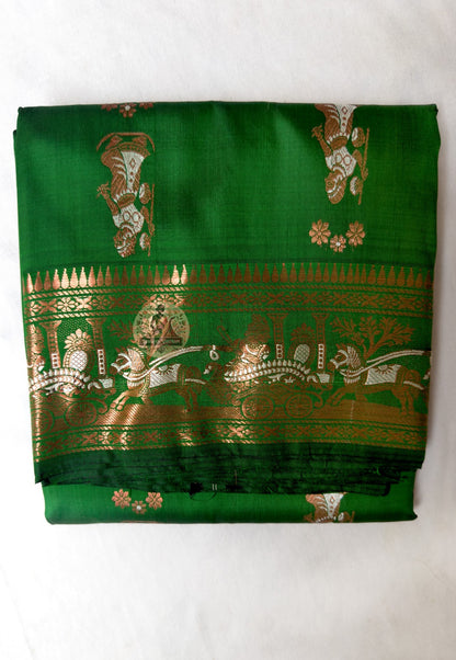 Full flat-lay of Swarnachari pure silk saree with fine golden zari detail border, precisely resolved narrative pallu, depth-rich buti field, and matching unstitched blouse piece, West Bengal handloom