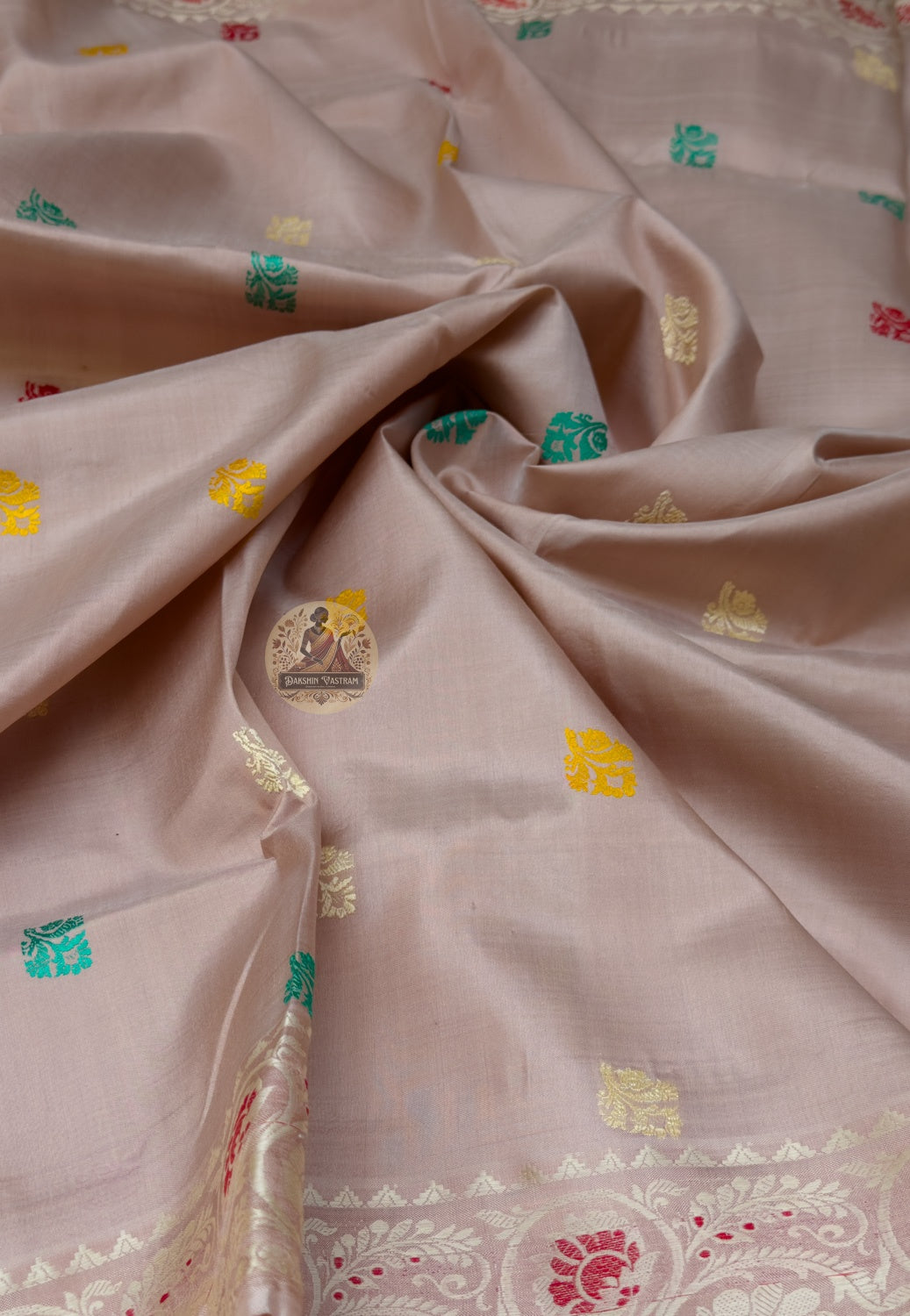 Rear view of beige Baluchari silk saree displaying a colourful paisley pallu over the shoulder
