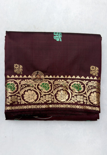 Close-up of Swarnachari silk saree pallu showing hand-woven golden zari dialogue panel with Bengal royal court figures and temple tradition motifs in exchange with the weaver's hand