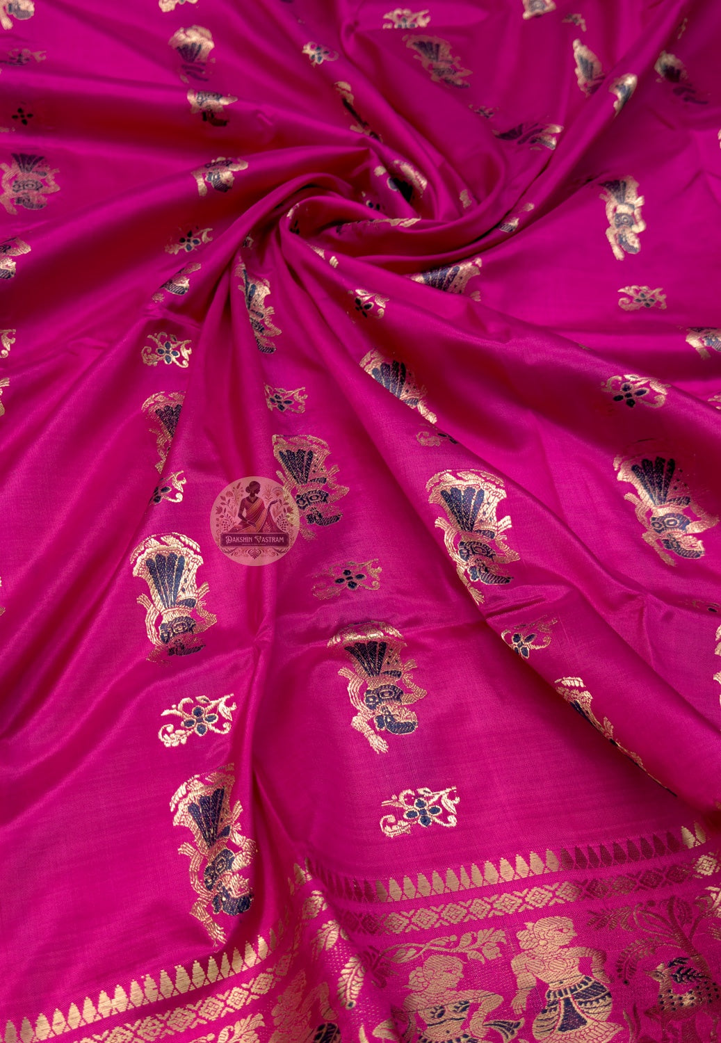 Close up of rani pink Swarnachari silk saree pallu with narrative panels and ornamental frames containing figures