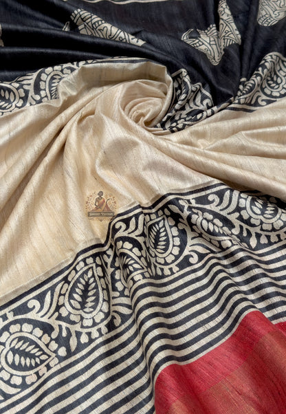 Close up of black elephant motifs and scrolling ornamental patterns on the cream saree pallu