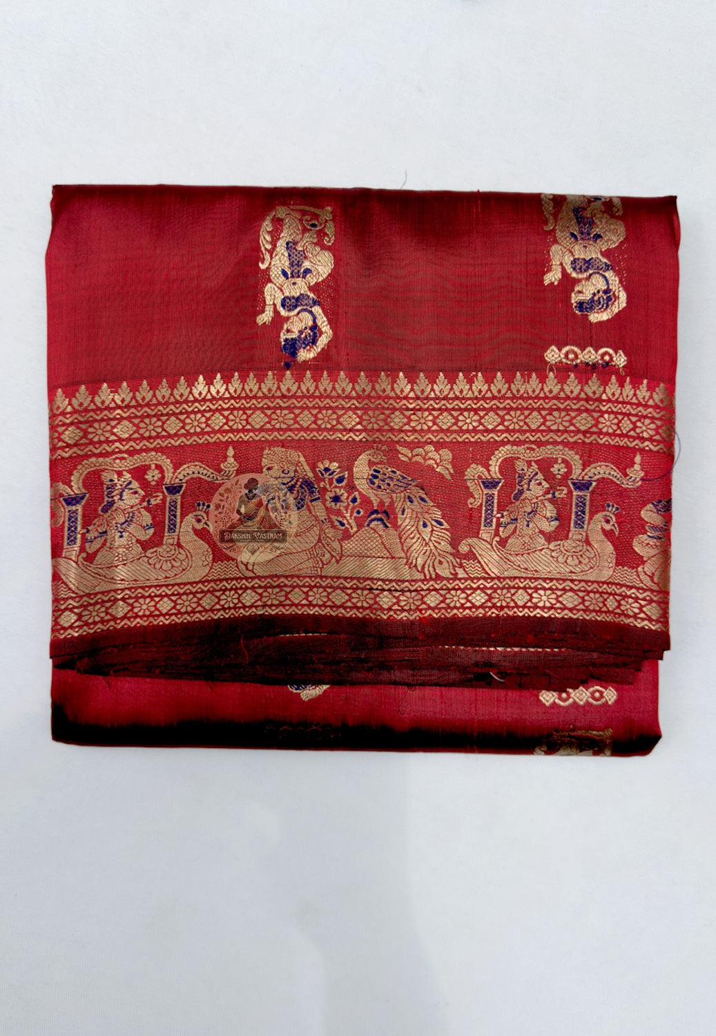 Close-up of Swarnachari silk saree pallu showing precision hand-woven golden zari panel with temple frieze and courtly procession motifs